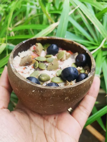 A simple, nutritious meal served in a coconut shell. This mix includes steamed meat, veggies, and is topped with pumpkin seeds and blueberries for extra goodness.