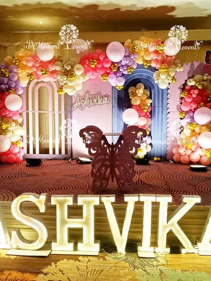 A vibrant and colorful butterfly-themed stage with marquee letters, perfect for a lively and cheerful birthday celebration.