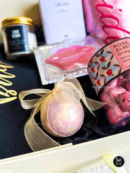 A detailed shot of a beautiful, shimmering bath bomb tied with an organza ribbon, a perfect addition to any bridal pamper hamper.