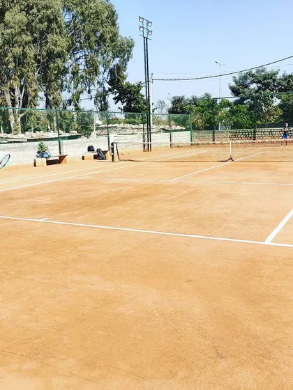 A wide view of a match in progress during the Tennis360 Academy UTR tour on a sunny day.
