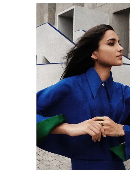 A detail shot showing the unique winged sleeves of this blue Payal Khandwala shirt, set against the geometric lines of the building.