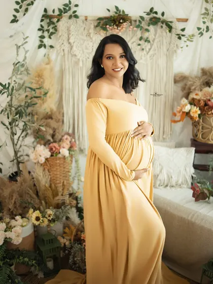 A radiant solo portrait of a mother-to-be. The warm yellow gown and her joyful expression perfectly capture the sunshine she's bringing into the world.