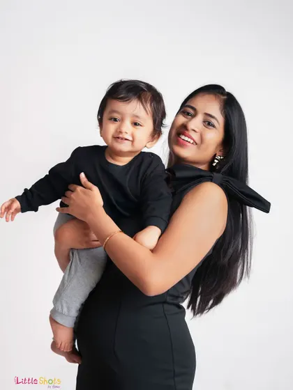 A happy mother holding her smiling baby. This classic portrait against a clean white background is timeless and full of love.