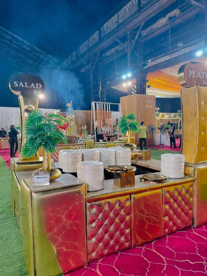 A wide shot of our catering setup, with the salad and plate station in the foreground and the smoky barbecue area in the back.