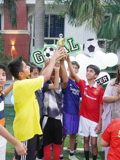 Victory! The winning team of the birthday football match celebrates with their trophy. It's moments like these that make the celebration truly memorable.