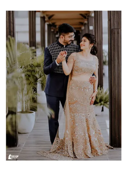 A classic engagement portrait of Shubham and Airika, walking hand-in-hand in a modern, elegant setting.