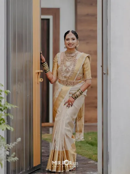 A full-length shot of the bride, her elegant pose and the beautiful drape of her saree creating a stunning visual.