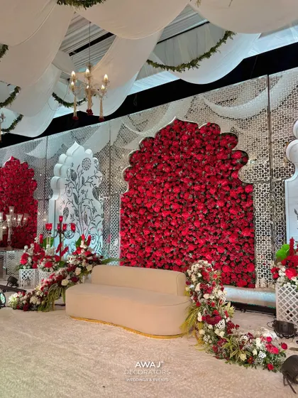 A side angle of the regal red and white stage, showing the depth of the floral arrangements and the intricate 'jaali' work on the side panels.
