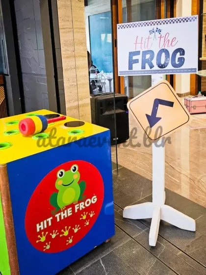 I provide interactive party games to keep the little ones entertained, like this "Hit the Frog" station that fits perfectly within the fun, playful vibe of the event.