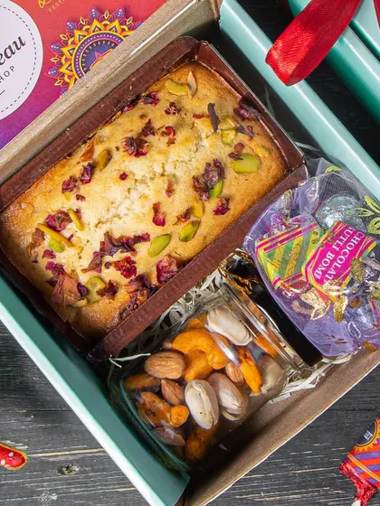 Our budget-friendly Diwali Mini Hamper. It includes a Mawa Pistachio cake, a jar of dry fruits, and our popular cracker chocolates, all packed in a lovely box.