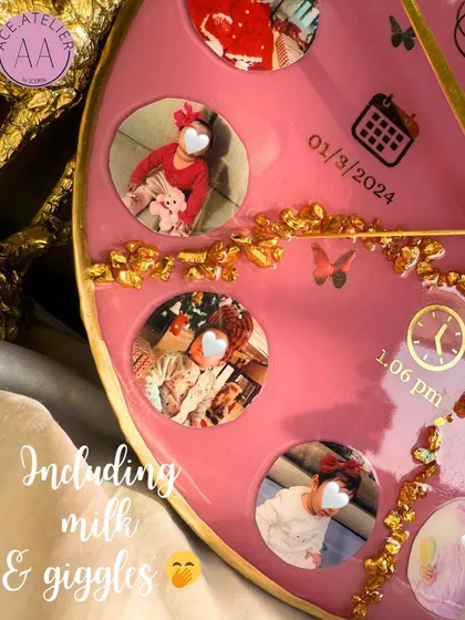 A close-up on the details, including milk and giggles. This shot highlights the small photos and personalized icons like the birth date and time on the baby clock.