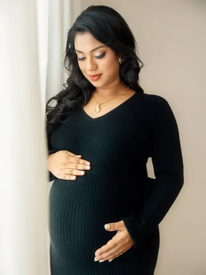 A quiet, downward glance at the baby bump. This pose creates a sense of introspection and deep connection between mother and child.