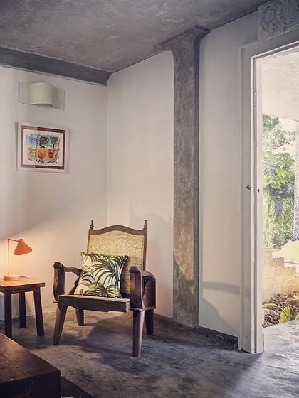 The lobby of the Garden Room at Jalakara, a calm, transitional space furnished with classic wooden pieces.