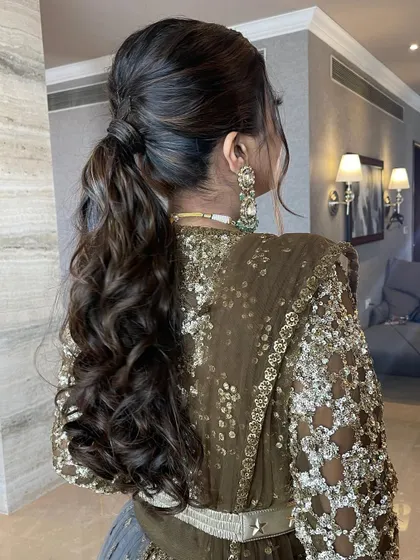 A messy ponytail with a small braid detail at the top, adding a touch of intricacy to the style.