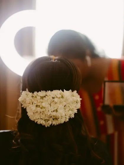 A close-up of a bride's hair adorned with a traditional jasmine garland, captured during her getting-ready moments.