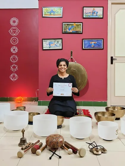A graduate holds her certificate, surrounded by the instruments of her training. Her dedication is commendable, and I am excited to see her share the healing power of sound.