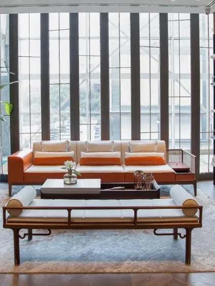 We balanced hard and soft materials in this airy living room. The modular sofa features a wood frame with cane work, while the floor-to-ceiling bookshelf is crafted from black cane and wood for a linear, lightweight feel.
