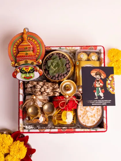 An overhead view of the fully assembled 'Ponnonam' luxury Onam hamper. This shot highlights the careful arrangement of each item, from the Kathakali decor to the jarred traditional snacks and the Mahabali greeting card.