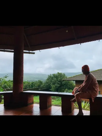 I take a moment of quiet reflection on the ashram veranda. The serene atmosphere is essential for absorbing the deep philosophical teachings we explore.