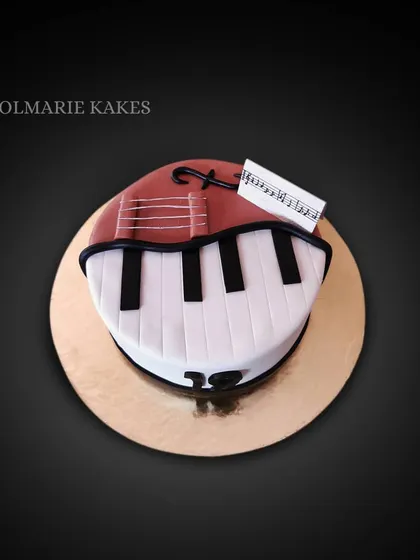 A cake for the musician. This design combines a guitar and a piano keyboard, celebrating a love for music in a sweet, edible form.