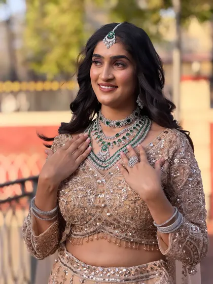 The bride is adjusting her necklace, and her soft, wavy hair falls beautifully over her shoulders. This style is perfect for a modern, elegant bride.