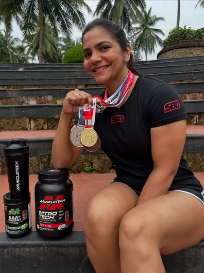 Posing with my medals and the supplements that powered my performance. I placed second overall and first in the deadlift with a new national record at the 2025 championship in Kozhikode.