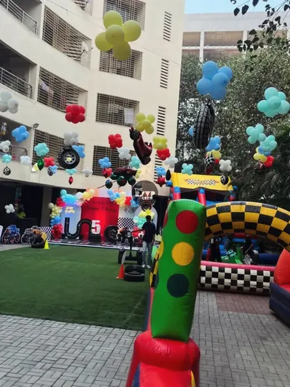 A full view of the Hot Wheels party zone, showing the inflatable racetrack, the main stage, and the decorated surroundings.
