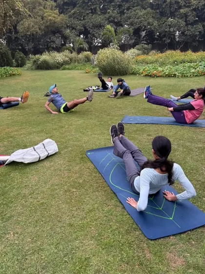 Core work is the foundation of a strong runner. Here, our tribe members are engaged in leg raises and other ab exercises during an outdoor session, building the stability needed for long distances.