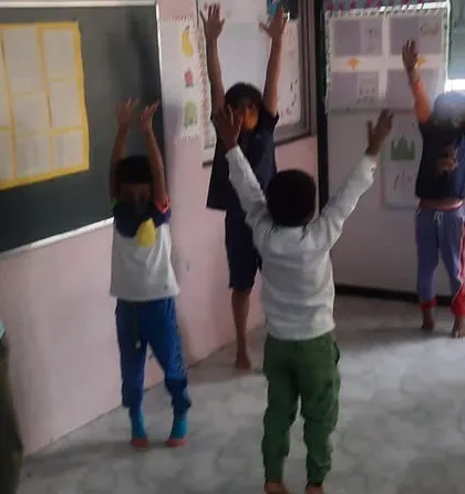 Another group of children practicing a standing pose. Regular yoga practice can improve concentration and emotional regulation.