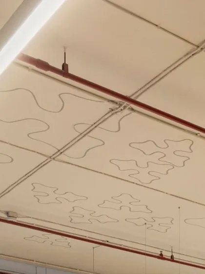 A detail shot of the stenciled patterns on the exposed ceiling of the Carlsberg office, a subtle nod to the brand's identity.