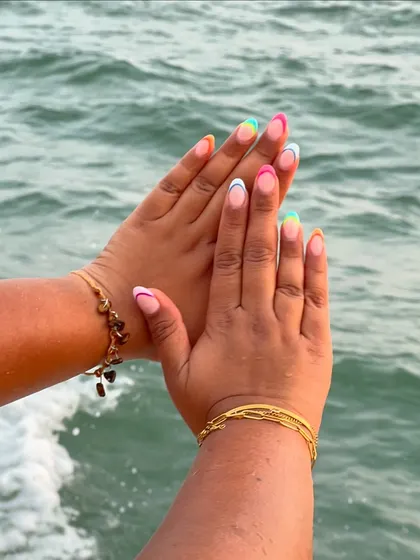 My client captured this beautiful shot of her colorful French tip nails against the ocean. It's the perfect holiday nail look.