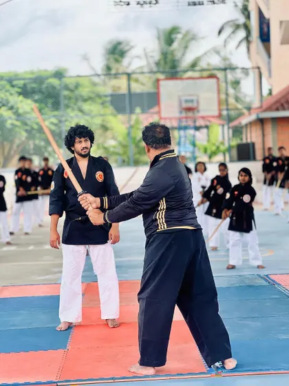 An instructor provides one-on-one correction to a student during the samurai workshop.