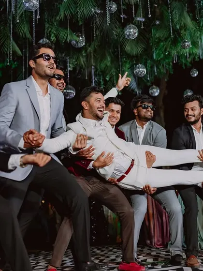 The groom is lifted by his friends in a moment of pure celebration on the sangeet dance floor.