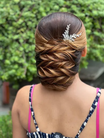 A finished look of a traditional low bun with highlighted hair, showing how color can enhance the texture of the style.