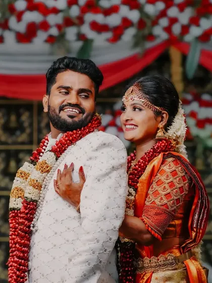 A sweet, candid moment between the bride and groom against the backdrop of their wedding stage. Their natural smiles and interaction are the focus of this wedding portrait.
