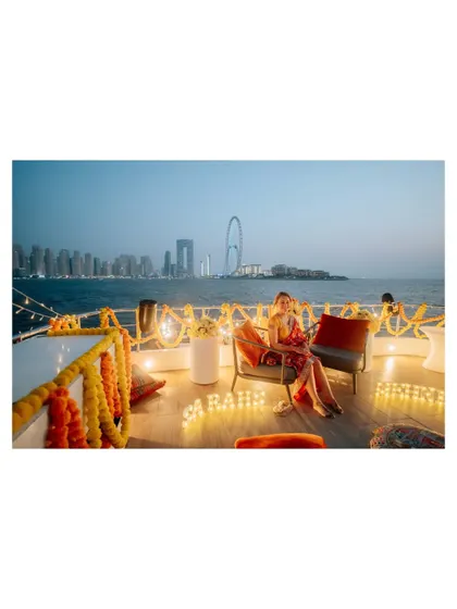The bride relaxing during her yacht party, with the beautiful Dubai cityscape behind her. A moment of calm amidst the celebration.