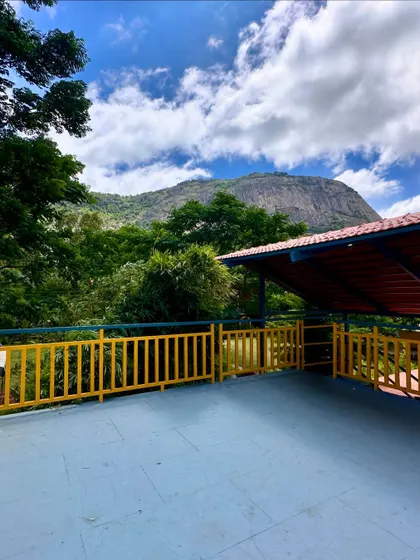 The stunning view from the balcony at our Nandi Hills resort. You can see the hills and lush trees, offering a peaceful and scenic environment for your team retreat.