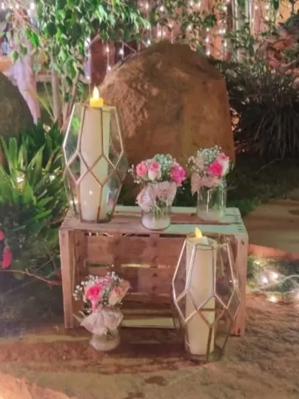 Rustic wooden crates used as stands for geometric lanterns and small floral bouquets, creating a charming and stylish decor vignette.