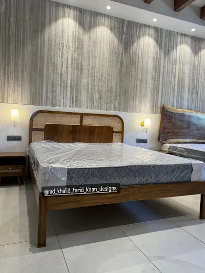 A full view of the custom bed with the cane headboard, showing its solid teak frame and simple, elegant construction, perfect for a modern hotel interior.