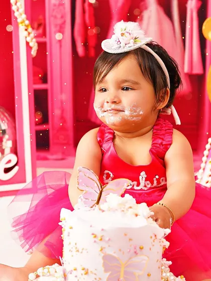 The aftermath of a glamorous Barbie cake smash. Her happy, messy face is the perfect end to a sweet celebration.