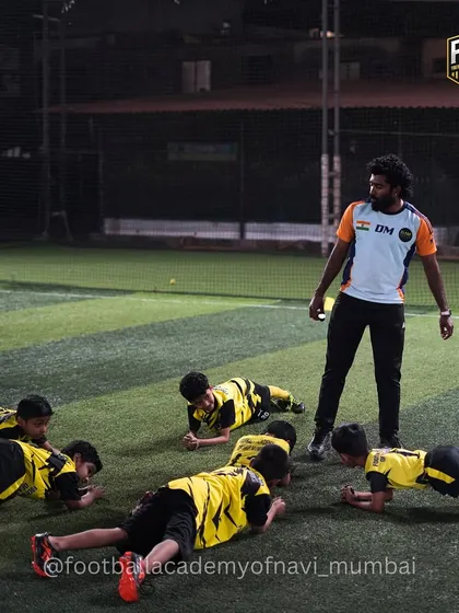 I lead a group of young players in a planking exercise. Building core strength is vital for stability, power, and injury prevention in football.