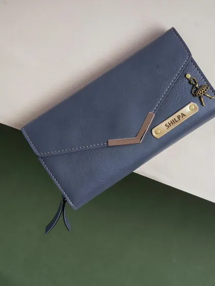 Duplicate of 93. A close-up of the blue Nexa clutch, personalized with the name "Shilpa" and an elegant ballerina charm.