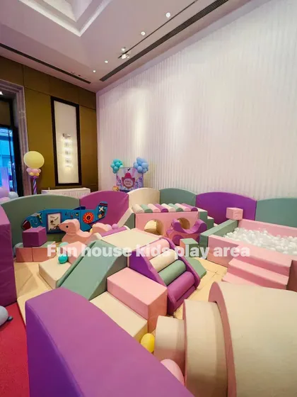 Another angle of the large indoor pastel play area, highlighting the variety of climbing and sliding options.