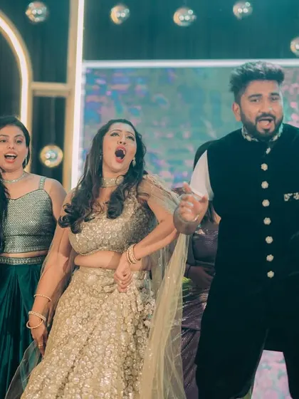 The couple and their friends singing their hearts out on the dance floor, a perfect candid party moment.