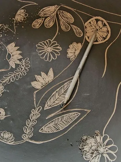 This is the sgraffito process I used for the memorial plate of my rabbit, Sonu. I'm carefully carving his image into the clay.