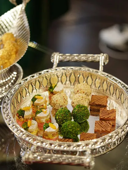 A festive tray adorned with delightful sweets, bringing warmth and celebration to the occasion. The intricate design of the silver-plated tray enhances the presentation.