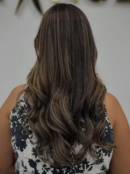 The back view shows the beautiful balayage effect, with lighter pieces woven through the brown base.