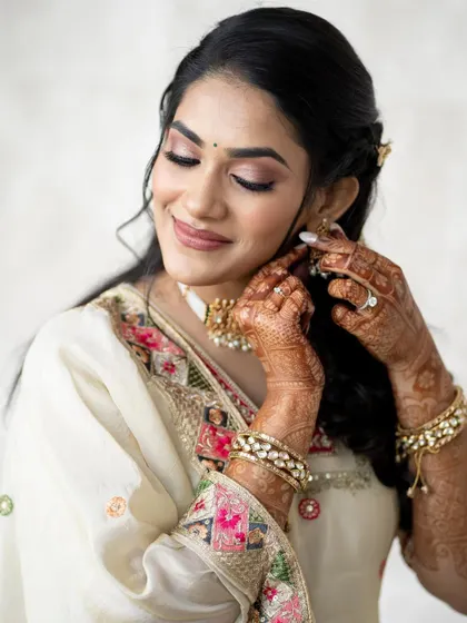 Another shot of her putting on her earrings, showing her intricate henna.