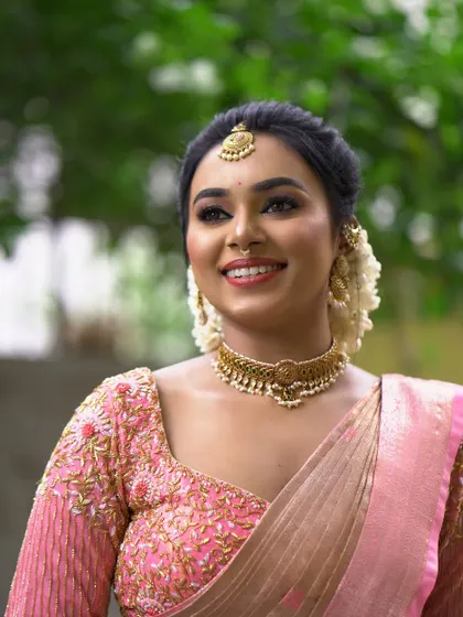 A happy, candid moment of a bride. The natural-looking makeup and fresh jasmine flowers in her hair create a look of effortless beauty.