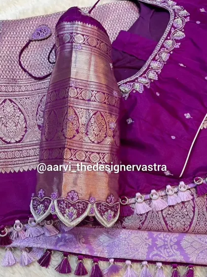 A stunning purple blouse with silver zari work. The scalloped edges on the sleeves and the custom tassels add a touch of modern elegance.